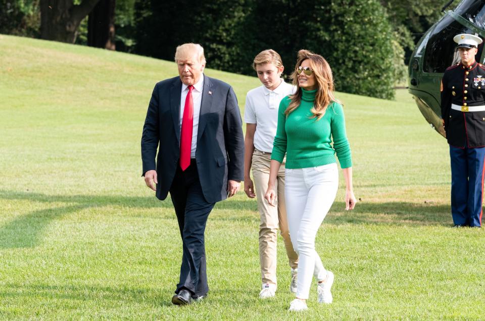 Crossing the White House lawn with her husband, the President, and son, Baron, Melanie kept it casual in white skinny jeans and a bright green poloneck jumper. [Photo: Rex]