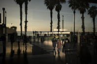 People walk past the entrance of Hospital del Mar, in Barcelona, Spain, Tuesday, Jan. 19, 2021. The unrelenting increase in COVID-19 infections in Spain following the holiday season is again straining hospitals, threatening the mental health of doctors and nurses who have been at the forefront of the pandemic for nearly a year. (AP Photo/Felipe Dana)