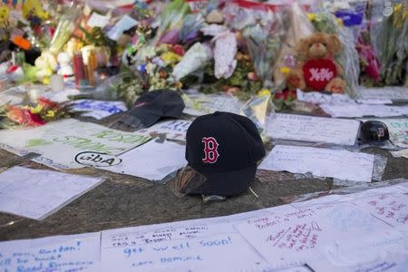 A Boston Red Sox hat is seen among a makeshift memorial for the victims of the Boston Marathon bombings on Boylston street in Boston, Massachusetts April 18, 2013. REUTERS/Shannon Stapleton