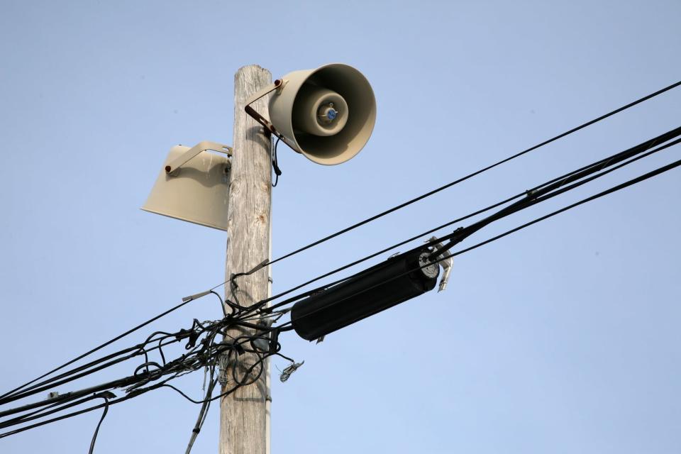 Warning sirens atop utility pole