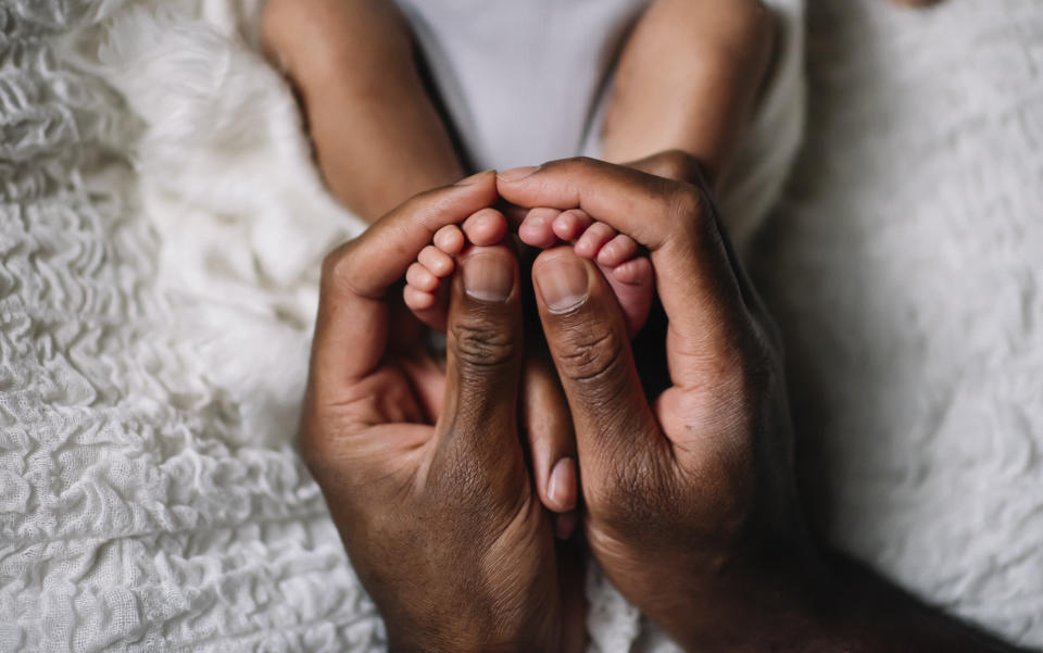 Baby's feet in father's hands