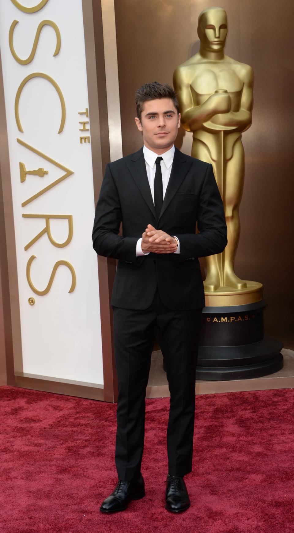 Actor Zac Efron arrives on the red carpet for the 86th Academy Awards on March 2nd, 2014 in Hollywood, California. AFP PHOTO / Robyn BECK        (Photo credit should read ROBYN BECK/AFP/Getty Images)