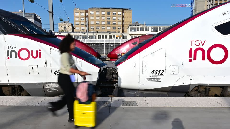 A passenger walks with luggage past a TGV speed train on the platforms of Paris' Gare du Nord station, on October 7, 2023. - Miguel Medina/AFP/Getty Images