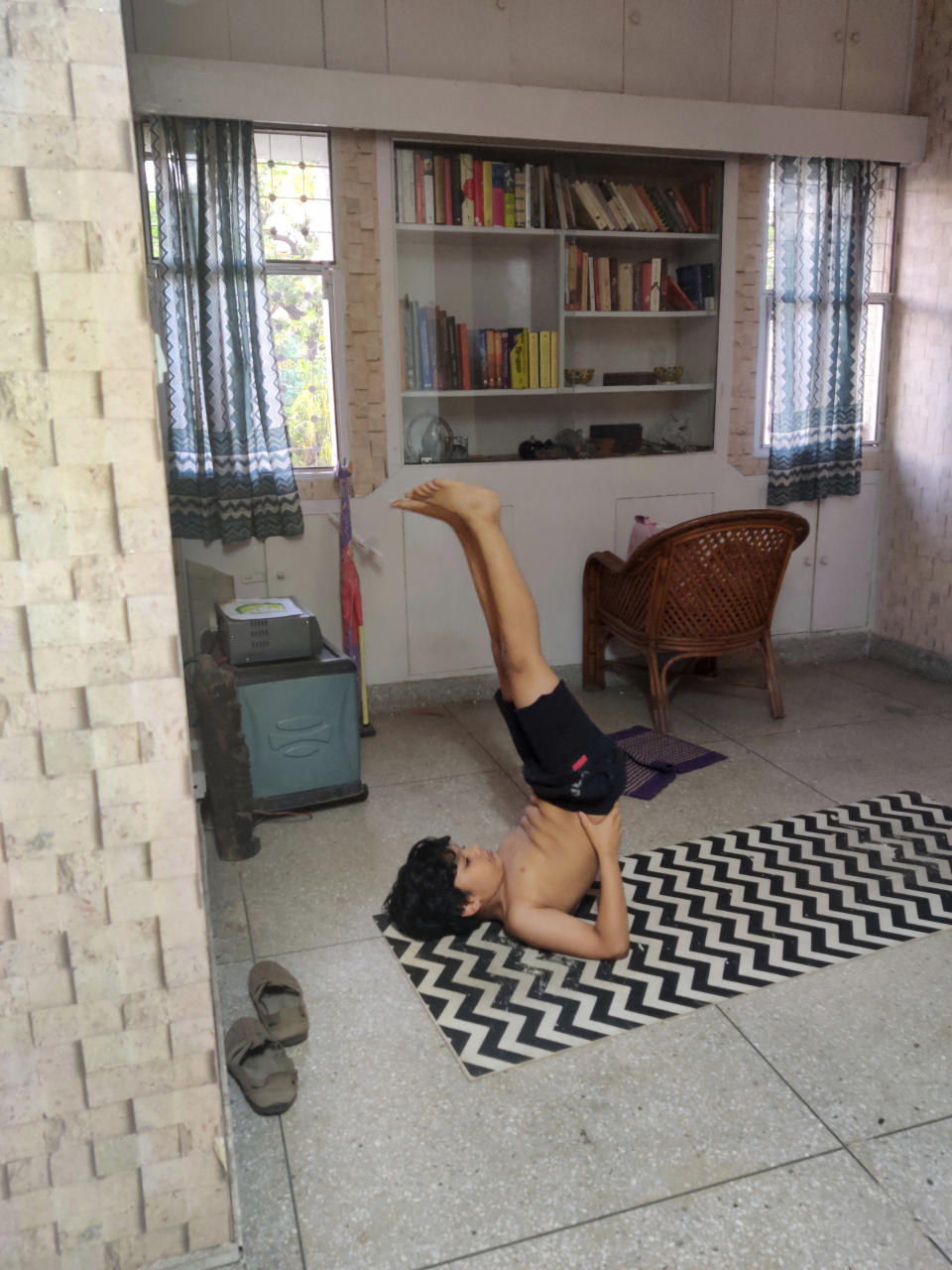 In this Tuesday, April 21, 2020 photo provided by Anil Sanweria, his son, Uddhav Pratap, 8, practices yoga in their home during a nationwide COVID-19 coronavirus lockdown. (Anil Sanweria via AP)