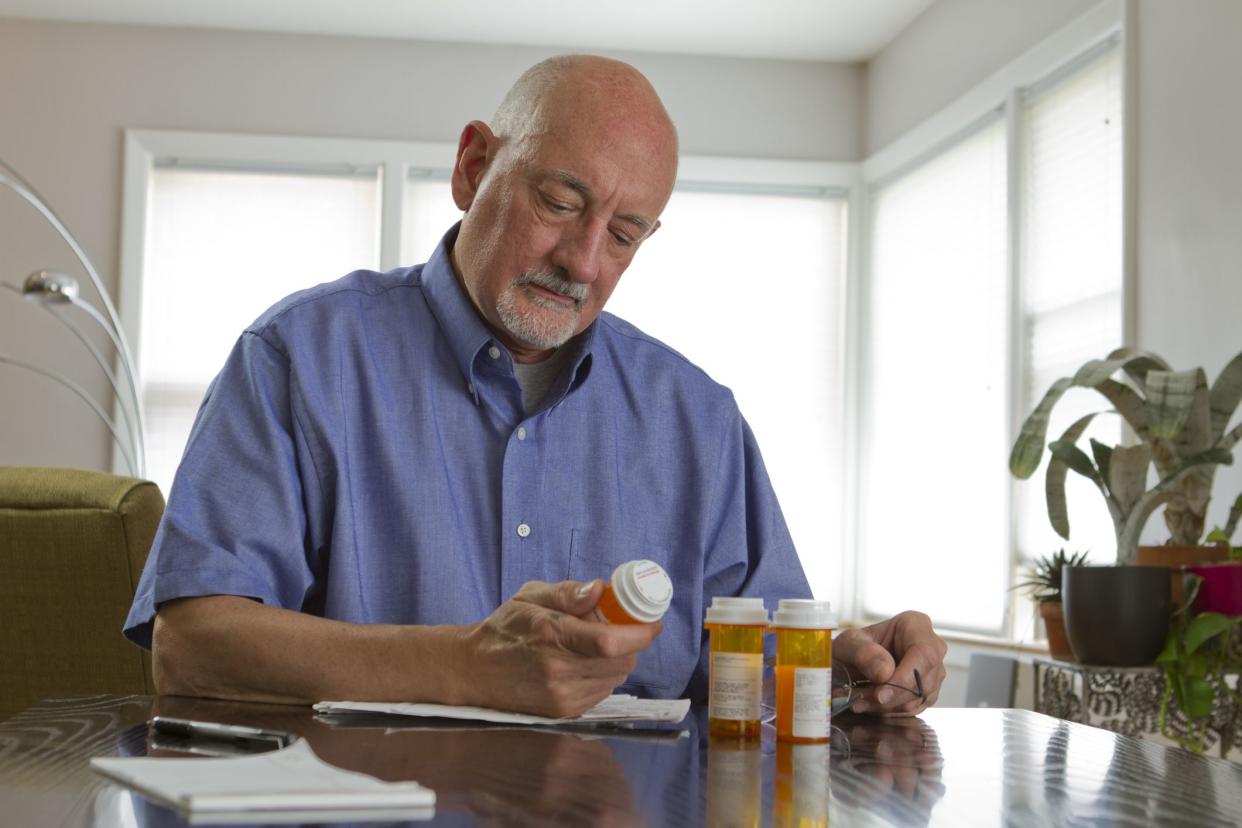 Older man reading prescription label, horizontal