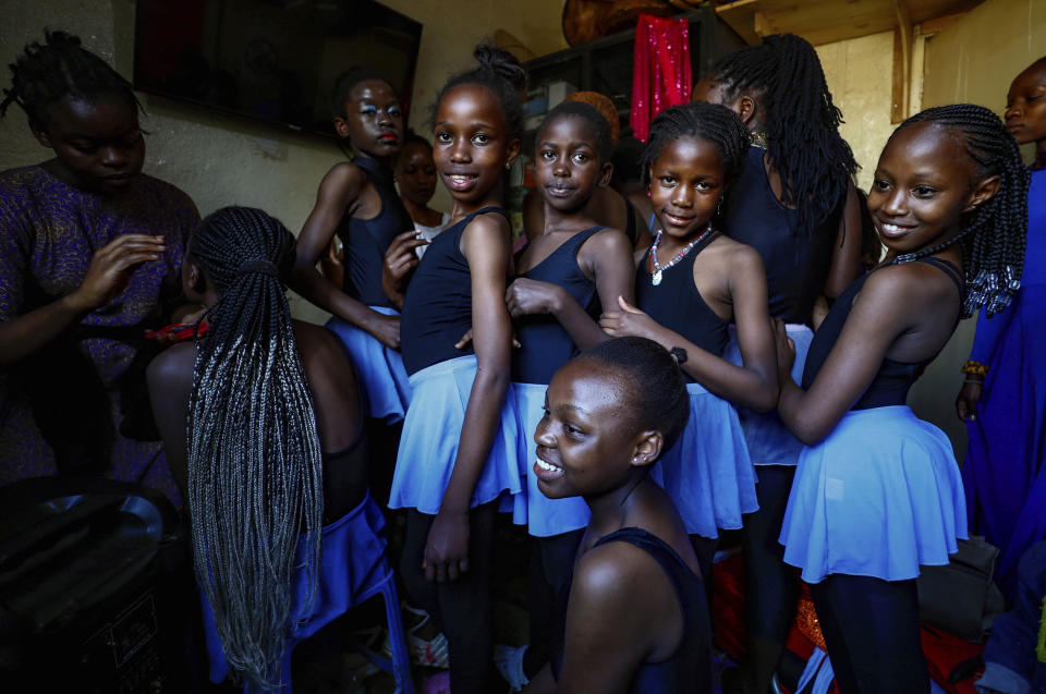 Young girls get their makeup applied at Project Elimu social hall, prior to the start of a Christmas ballet event in Kibera, one of the busiest neighborhoods of Kenya's capital, Nairobi, Friday, Dec. 15, 2023. The ballet project is run by Project Elimu, a community-driven nonprofit that offers after-school arts education and a safe space to children in Kibera. (AP Photo/Brian Inganga)