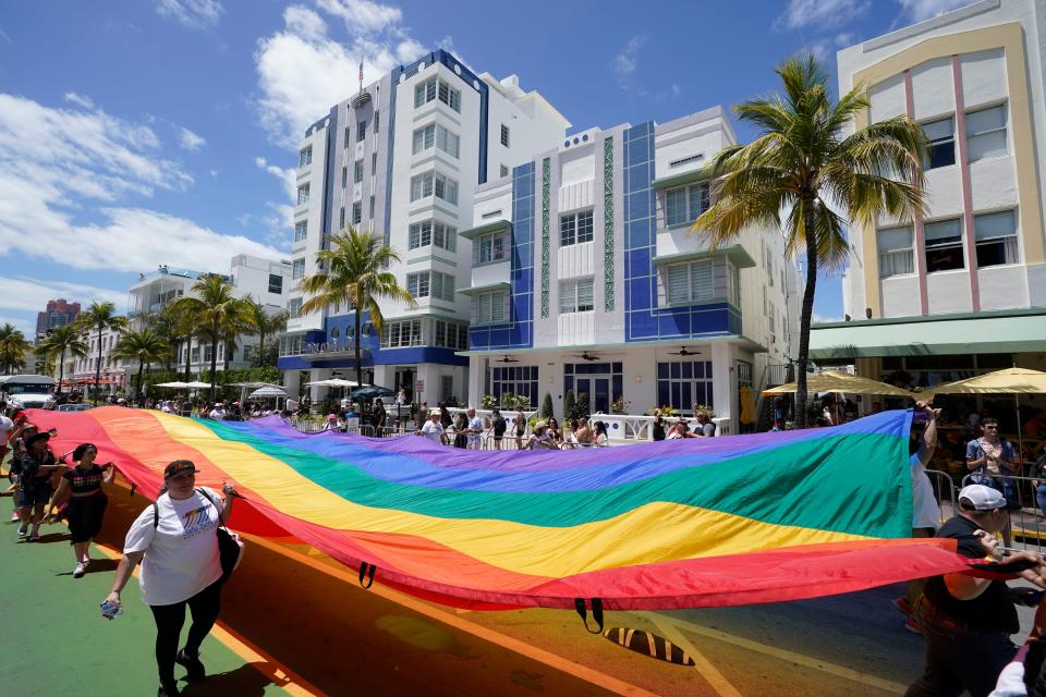 Participants carry a large rainbow flag down Ocean Drive during a Pride parade on Apr. 10, 2022, in front of Miami Beach, Florida's famed Art Deco hotels on South Beach. As the uses of words like "grooming" increase, advocates say rhetoric that references child sex abuse hurts the LGBTQ community, particularly gay men who have long been accused of predatory sexual behavior.