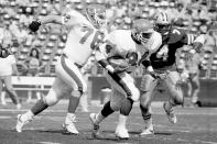 FILE - New Jersey Generals Herschel Walker, center, carries the ball for a first down past General's Bryan Millard, left, and Los Angeles Express' Dennis Edwards during the first quarter of an USFL game in Los Angeles on March 6, 1983. The original USFL was a league that made a whole lot of sense, only to be undone by the greed and hubris of owners such as former President Donald Trump, who saw the fledgling organization as a conduit to the NFL. (AP Photo/File)