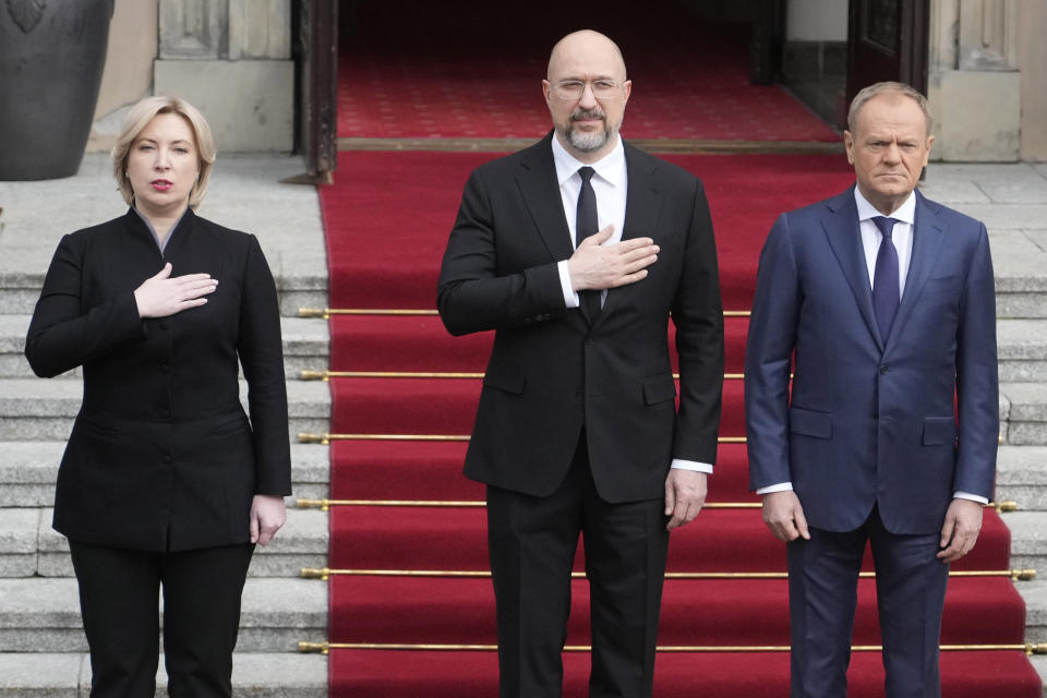 Ukrainian Prime Minister Denys Shmyhal, center, and his Polish counterpart, Prime Minister Donald Tusk, right, review troops during a welcoming ceremony ahead of their talks in Warsaw, Poland, Thursday March 28, 2024. (AP Photo/Czarek Sokolowski)