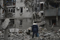 A woman stands among debris of the destroyed house after recent Russian air strike in Chasiv Yar, Ukraine, Sunday, Nov. 27, 2022. Shelling by Russian forces struck several areas in eastern and southern Ukraine overnight as utility crews continued a scramble to restore power, water and heating following widespread strikes in recent weeks, officials said Sunday. (AP Photo/Andriy Andriyenko)