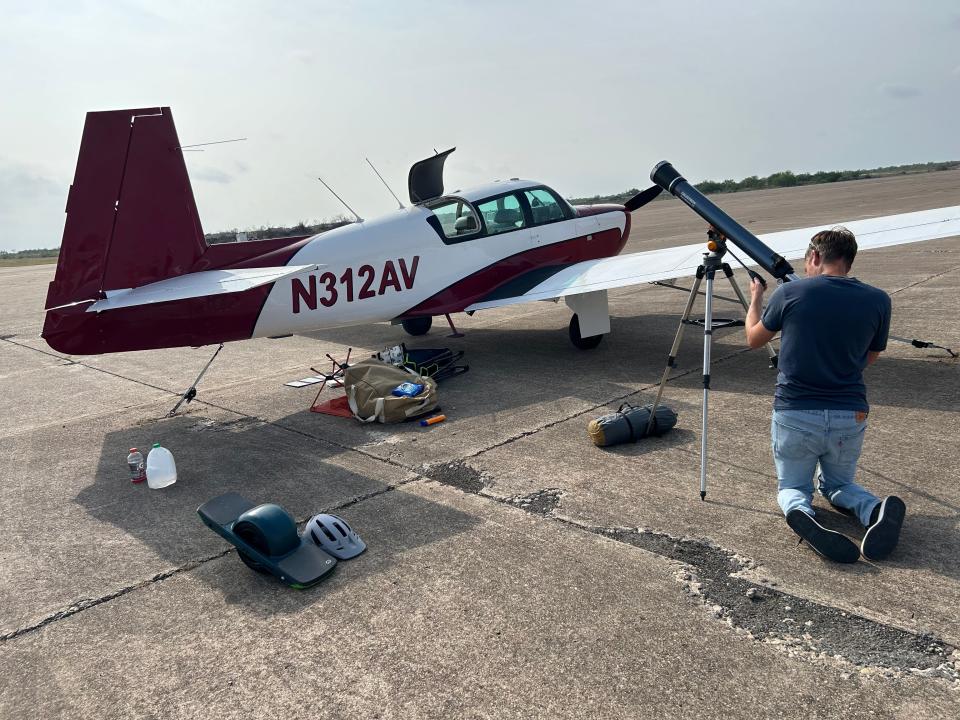 Brandon Beck, 43, from San Diego, adjusts his telescope next to his friend’s Mooney plane Monday on the tarmac of Maverick County International Airport in Eagle Pass, Texas. The airport will be one of the first places in the USA to experience totality during the solar eclipse.