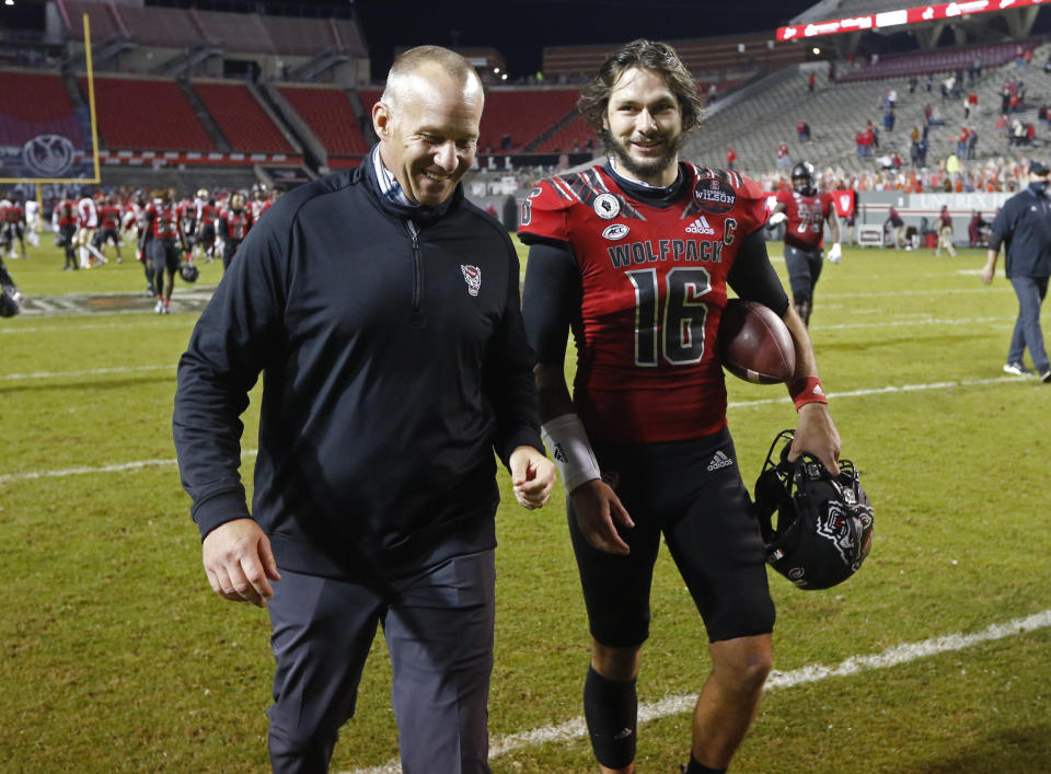 North Carolina State coach Dave Doeren laughs with quarterback Bailey Hockman (16) after the team's 38-22 victory over Florida Stateof an NCAA college football game Saturday, Nov. 14, 2020, in Raleigh, N.C. (Ethan Hyman/The News & Observer via AP, Pool)