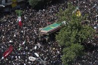 Iranians follow a truck carrying coffins of the late President Ebrahim Raisi and his companions who were killed in a helicopter crash on Sunday in a mountainous region of the country's northwest, during a funeral ceremony for them in Tehran, Iran, Wednesday, May 22, 2024. Iran's supreme leader presided over the funeral Wednesday for the country's late president, foreign minister and others killed in the helicopter crash, as tens of thousands later followed a procession of their caskets through the capital, Tehran. (AP Photo/Vahid Salemi)