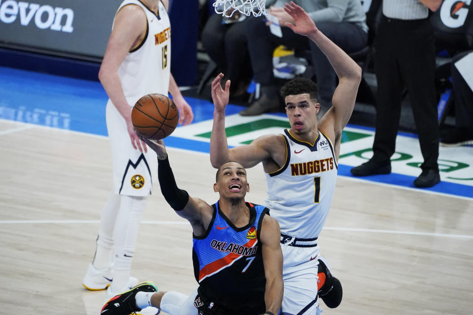 Oklahoma City Thunder forward Darius Bazley (7) is fouled by Denver Nuggets forward Michael Porter Jr. during the first half of an NBA basketball game Saturday, Feb. 27, 2021, in Oklahoma City. (AP Photo/Sue Ogrocki)