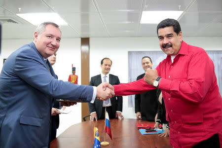Venezuela's President Nicolas Maduro (R) shakes hands with Russia's Deputy Prime Minister Dmitry Rogozin during a meeting at Miraflores Palace in Caracas, Venezuela December 6, 2016. Miraflores Palace/Handout via REUTERS