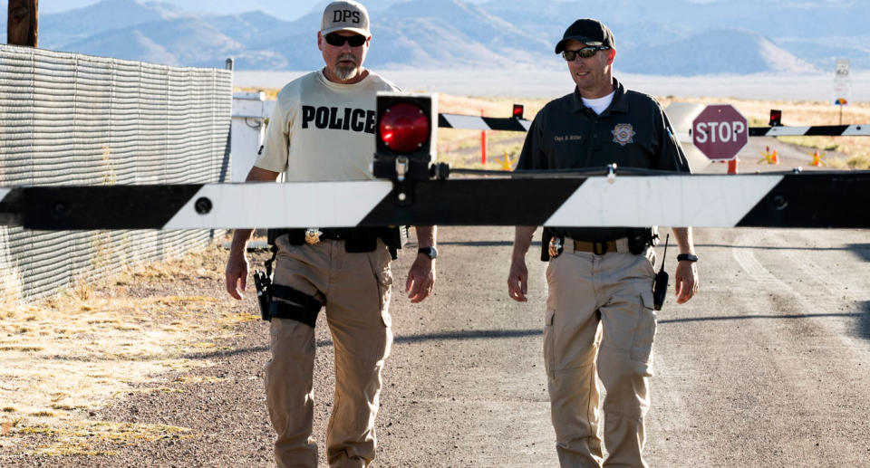 Police walk down gravel road at Area 51 site amid a scheduled raid in the Nevada desert.
