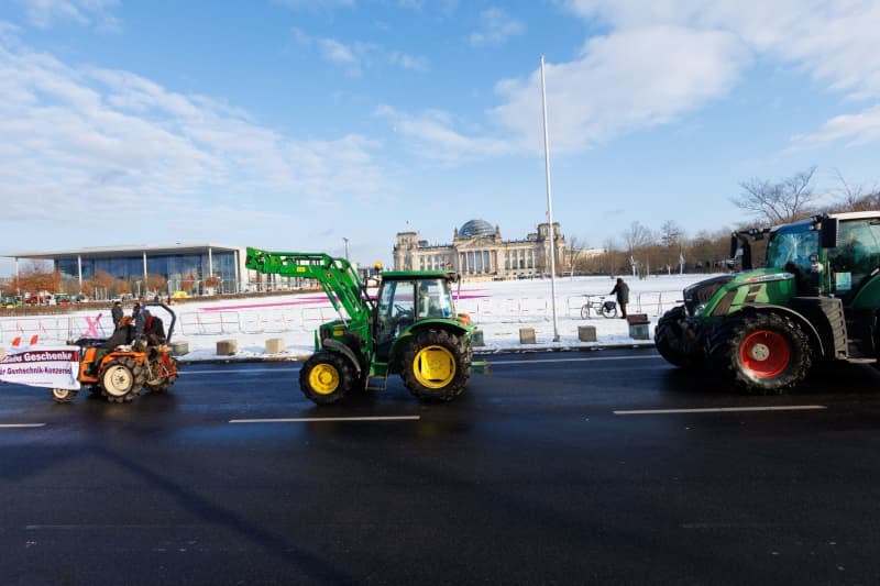 Farmers drive past the Reichstag building to the Federal Chancellery with tractors during a demonstration by the "We're fed up" alliance against agricultural policy. Carsten Koall/dpa
