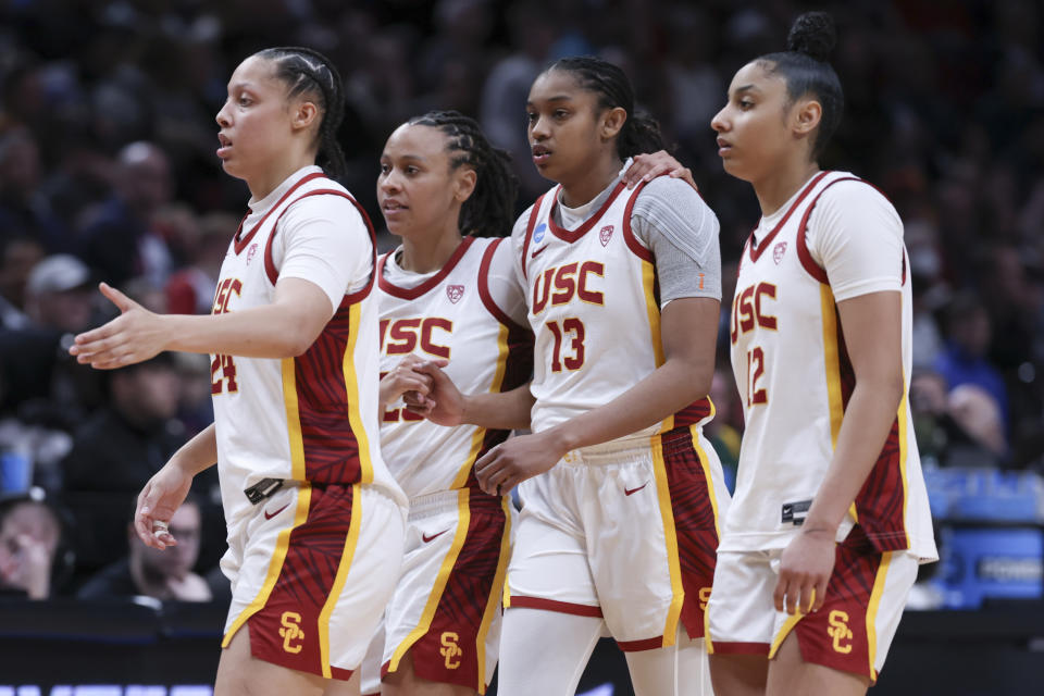 Southern California players Kaitlyn Davis, left, McKenzie Forbes, second from left, Rayah Marshall (13) and JuJu Watkins (12) react after a Sweet 16 college basketball game against Baylor in the women's NCAA Tournament, Saturday, March 30, 2024, in Portland, Ore. Southern California won 74-70. (AP Photo/Howard Lao)