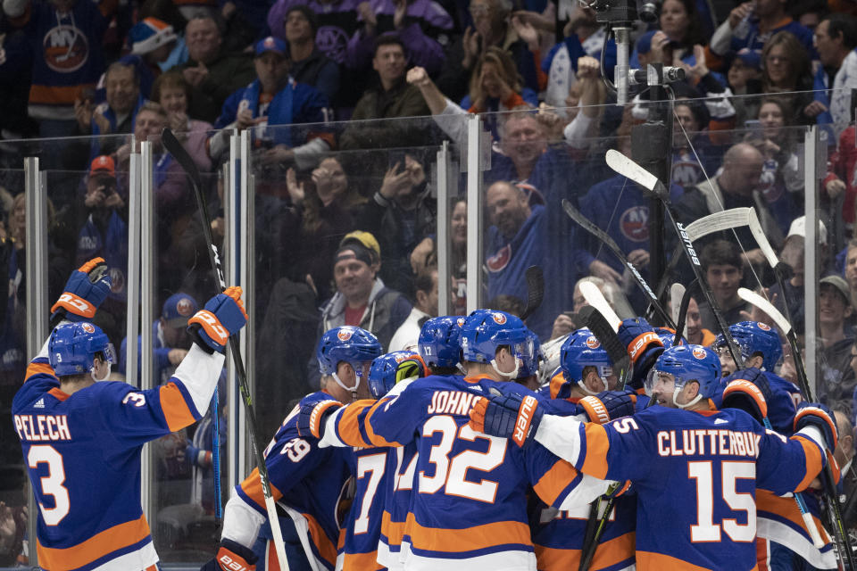 New York Islanders celebrate their 3-2 overtime win against Buffalo Sabres, Saturday, Dec. 14, 2019 in Uniondale, N.Y. (AP Photo/Mark Lennihan)