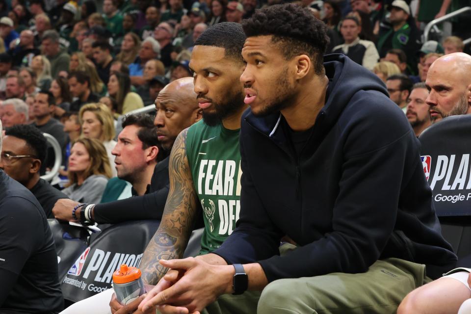 Damian Lillard, left, and Giannis Antetokounmpo of the Milwaukee Bucks watch from the sideline during Game 1 of the Eastern Conference playoffs against the Indiana Pacers at Fiserv Forum on April 21. Both players were officially listed as doubtful for Game 5 on Monday evening.