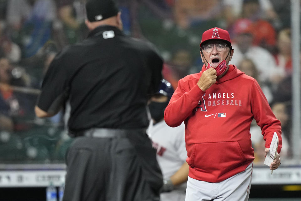 Los Angeles Angels manager Joe Maddon, right, argues a batter interference call by home plate umpire Brian O'Nora, left, during the first inning of a baseball game against the Houston Astros Friday, April 23, 2021, in Houston. (AP Photo/David J. Phillip)