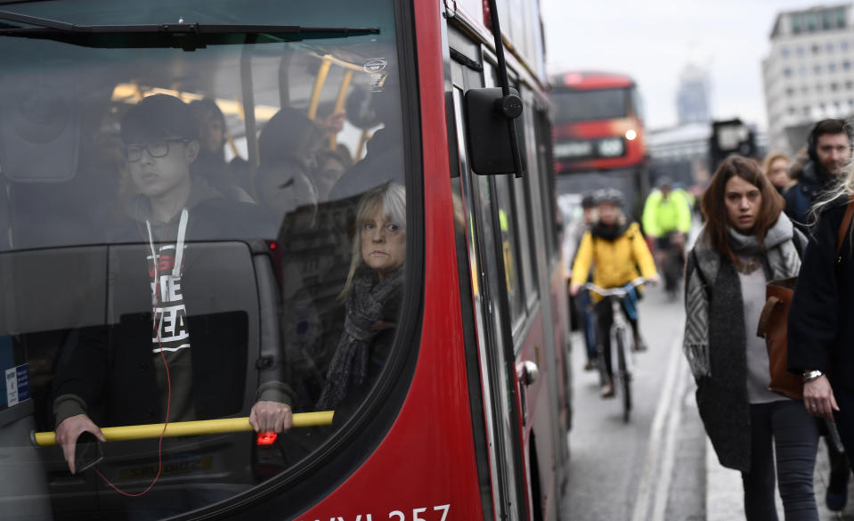 Commuters stand on a packed bus as others walk accross Waterloo Bridge during a strike on the Underground by members of two unions in protest at ticket office closures and reduced staffing levels, in London, Britain January 9, 2017. REUTERS/Dylan Martinez 