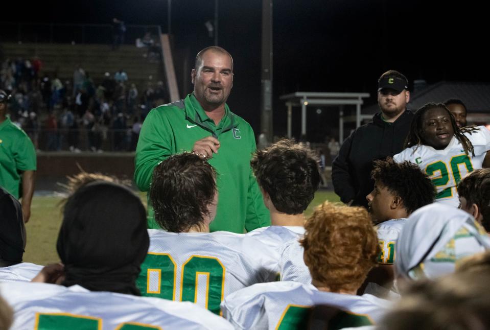 Crusaders head coach Matt Adams talks with his players after their 42-15 victory over the Braves during the Catholic vs Walton high school playoff football game at Walton HIgh School in DeFuniak Springs on Friday, Nov. 17, 2023.