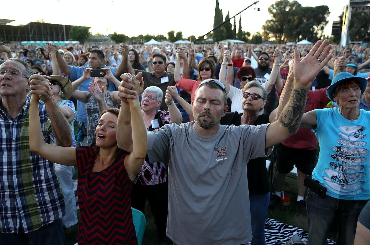 Evangelicals share the recognition of the Bible as the ultimate authority. <a href="https://www.gettyimages.com/detail/news-photo/attendees-hold-hands-and-pray-as-rev-franklin-graham-speaks-news-photo/963640408?adppopup=true" rel="nofollow noopener" target="_blank" data-ylk="slk:Justin Sullivan/Getty Images;elm:context_link;itc:0;sec:content-canvas" class="link ">Justin Sullivan/Getty Images</a>