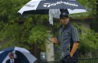 Sergio Garcia of Spain looks from under an umbrella during a rain delay prior to the start of the second round of the 2014 PGA Championship at Valhalla Golf Club in Louisville, Kentucky, August 8, 2014. REUTERS/Brian Snyder