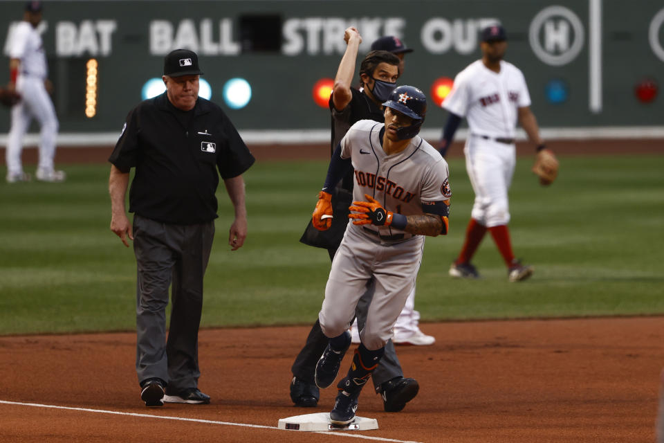 Houston Astros' Carlos Correa rounds the bases as umpire John Tumpane signals home run after conferring with umpire Brian Gorman, left, during the first inning of a baseball game against the Boston Red Sox Tuesday, June 8, 2021, at Fenway Park in Boston. (AP Photo/Winslow Townson)