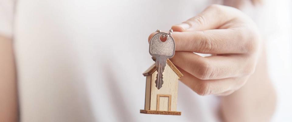 female hand holding keys to house