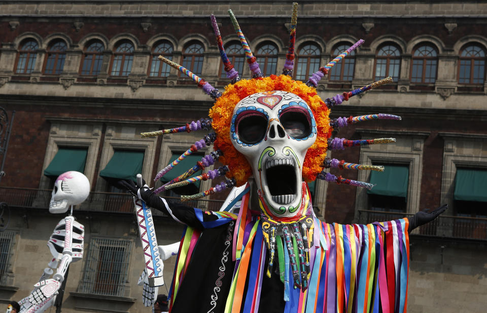 Performers in costume attend a Day of the Dead parade in Mexico City, Sunday, Oct. 27, 2019. The parade on Sunday marks the fourth consecutive year that the city has borrowed props from the opening scene of the James Bond film, “Spectre,” in which Daniel Craig’s title character dons a skull mask as he makes his way through a crowd of revelers. (AP Photo/Ginnette Riquelme)