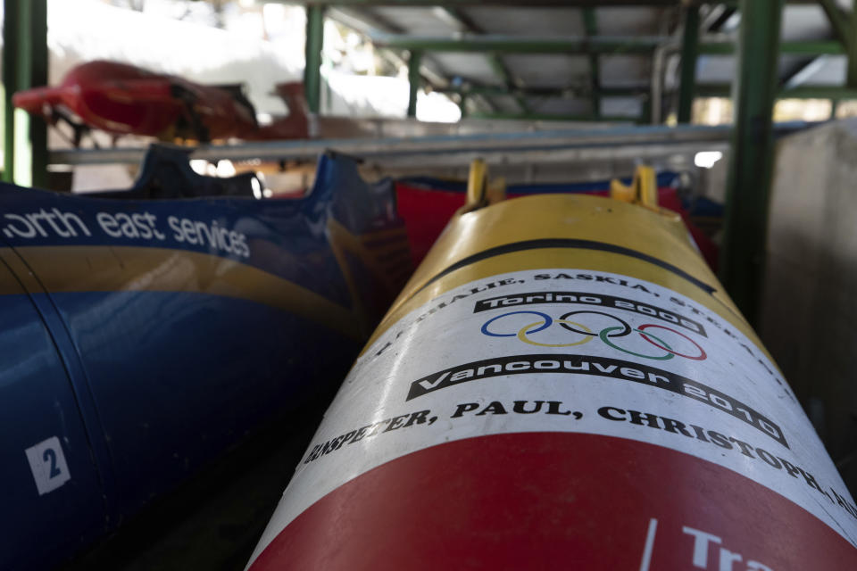 Bobsleds are stored next to the course in Cortina d'Ampezzo, Italy, Wednesday, Feb. 17, 2021. Bobsledding tradition in Cortina goes back nearly a century and locals are hoping that the Eugenio Monti track can be reopened for the 2026 Olympics in the Italian resort. (AP Photo/Gabriele Facciotti)