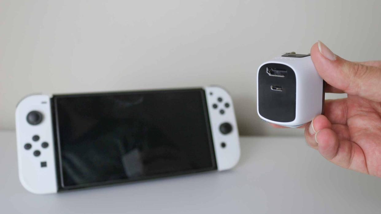  The Genki Covert Dock Mini next to a Nintendo Switch OLED. 