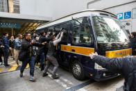 Photographers surround a prison van holding seven police officers that were convicted of assaulting Ken Tsang during the 2014 pro-democracy protests, as it leaves the District Court in Hong Kong on February 14, 2017