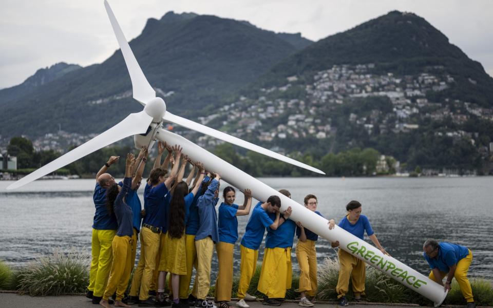 Activits of Greenpeace raise a replica wind turbine on the shore of Lake Lugano on the sidelines of the Ukraine Recovery Conference URC, in Lugano, Switzerland - ALESSANDRO DELLA VALLE/EPA-EFE/Shutterstock/Shutterstock