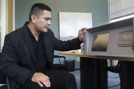 Cybersecurity researcher Billy Rios looks over a Pyxis medical supply dispenser in Redwood City, California October 10, 2014. REUTERS/Robert Galbraith