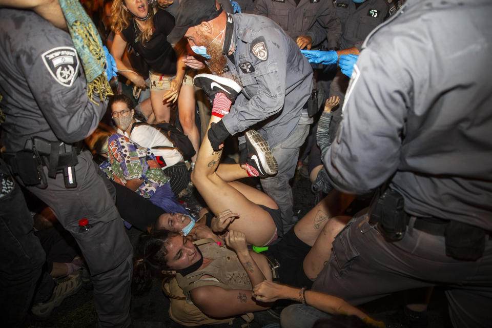 Israeli police scuffle with demonstrators during a protest against Israel's Prime Minister Benjamin Netanyahu outside his residence in Jerusalem, early Wednesday, July 22, 2020. Protesters demanded that the embattled leader resign as he faces a trial on corruption charges and grapples with a deepening coronavirus crisis. (AP Photo/Ariel Schalit)