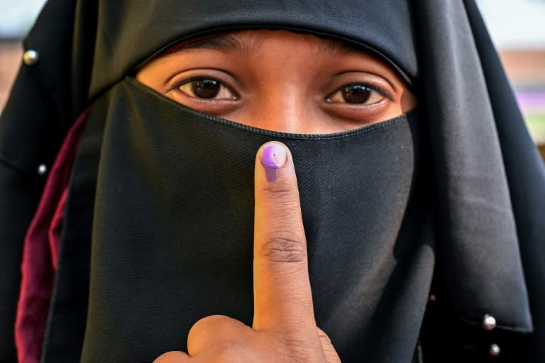 A woman shows her inked finger after casting her ballot at a polling station during the second phase of voting in India's general election (Biju BORO)