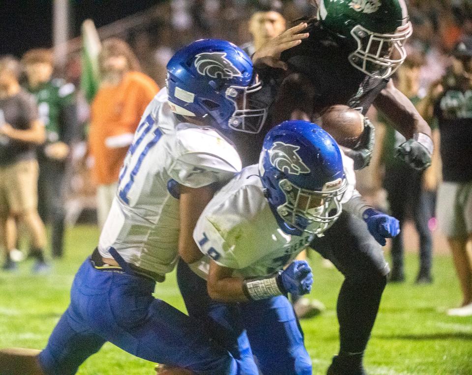 Manteca's Bryson Davis (7), center, powers through Sierra's Aydan Harris (21), left, and Nikko Camarena (19) during a varsity football game at Manteca's Gus Schmiedt Stadium on Friday, Oct. 7, 2022. 