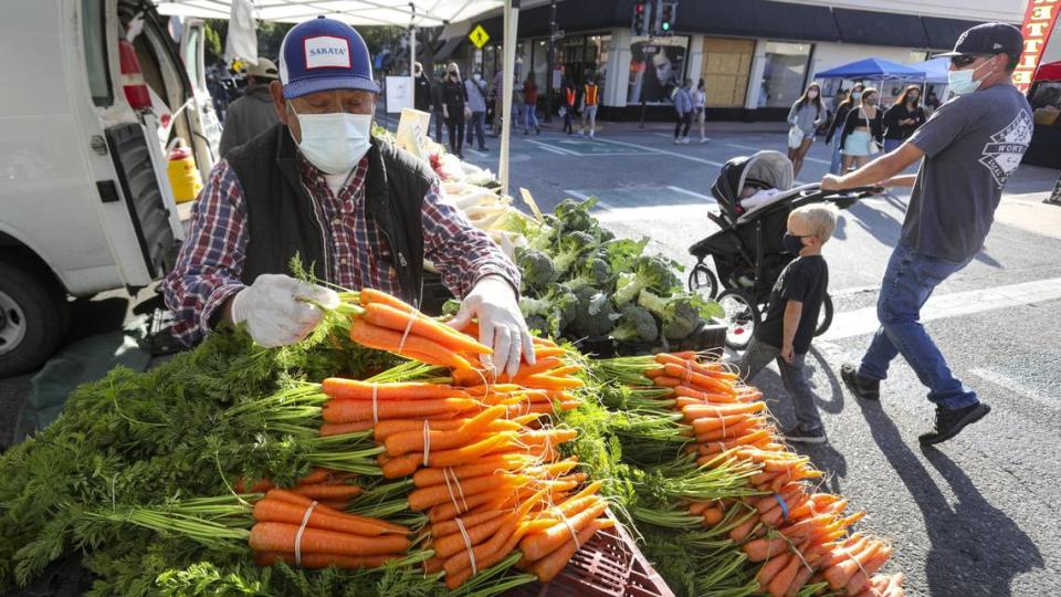 Francisco Velazquez of Santa Maria sets out carrots from his farm on May 6, 2021. The website Eat This, Not That! has named the event the best in California in a national survey.