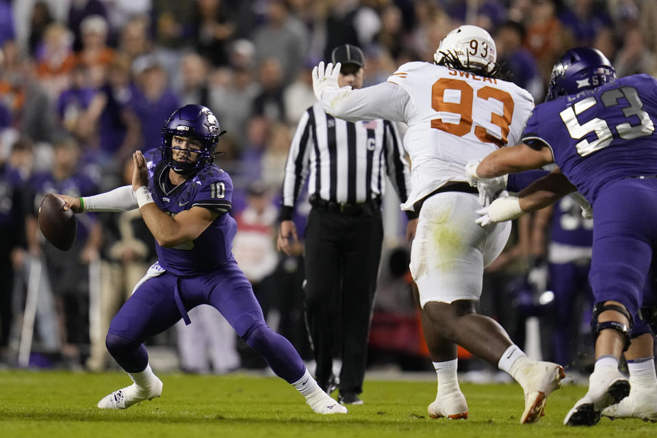 TCU quarterback Josh Hoover (10) scrambles as Texas defensive lineman T'Vondre Sweat (93) tries to bring him down during the first half of an NCAA college football game, Saturday, Nov. 11, 2023, in Fort Worth, Texas. (AP Photo/Julio Cortez)