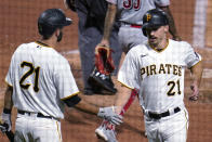 Pittsburgh Pirates' Bryan Reynolds, right, is greeted by Jacob Stallings after scoring on a sacrifice fly by Colin Moran during the third inning against the Cincinnati Reds in a baseball game in Pittsburgh, Wednesday, Sept. 15, 2021. All Pirates players wore No. 21 in honor of Roberto Clemente Day. (AP Photo/Gene J. Puskar)