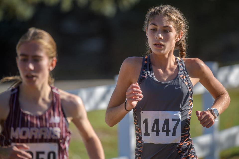 Washington freshman Sophia Ramirez keeps pace with Morris senior Joy Dudley during the Class 2A cross-country sectional Saturday, Oct. 29, 2022 at Black Partridge Park in Metamora. Ramirez finished second to lead Washington to a sectional title.