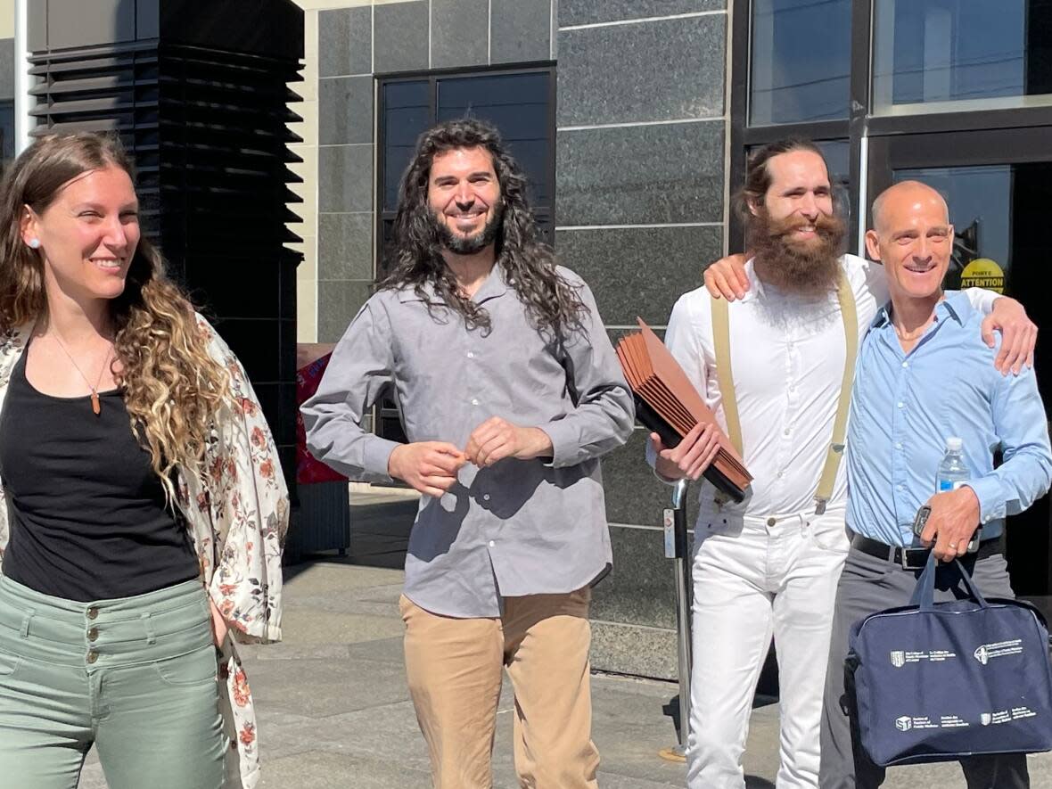 Britney Green, left, Nicholas DeAngelis, a supporter who has assisted them, and David West leave the Moncton courthouse Tuesday morning. (Shane Magee/CBC - image credit)