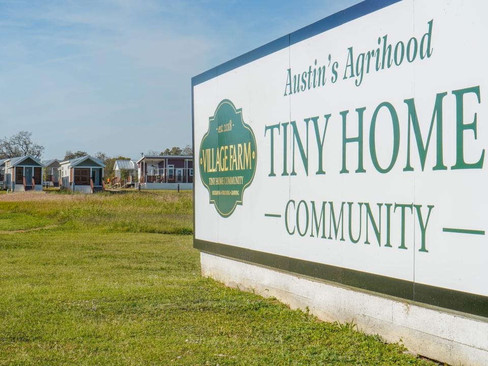 A sign reads "Austin's Agrihood Tiny Home Community"