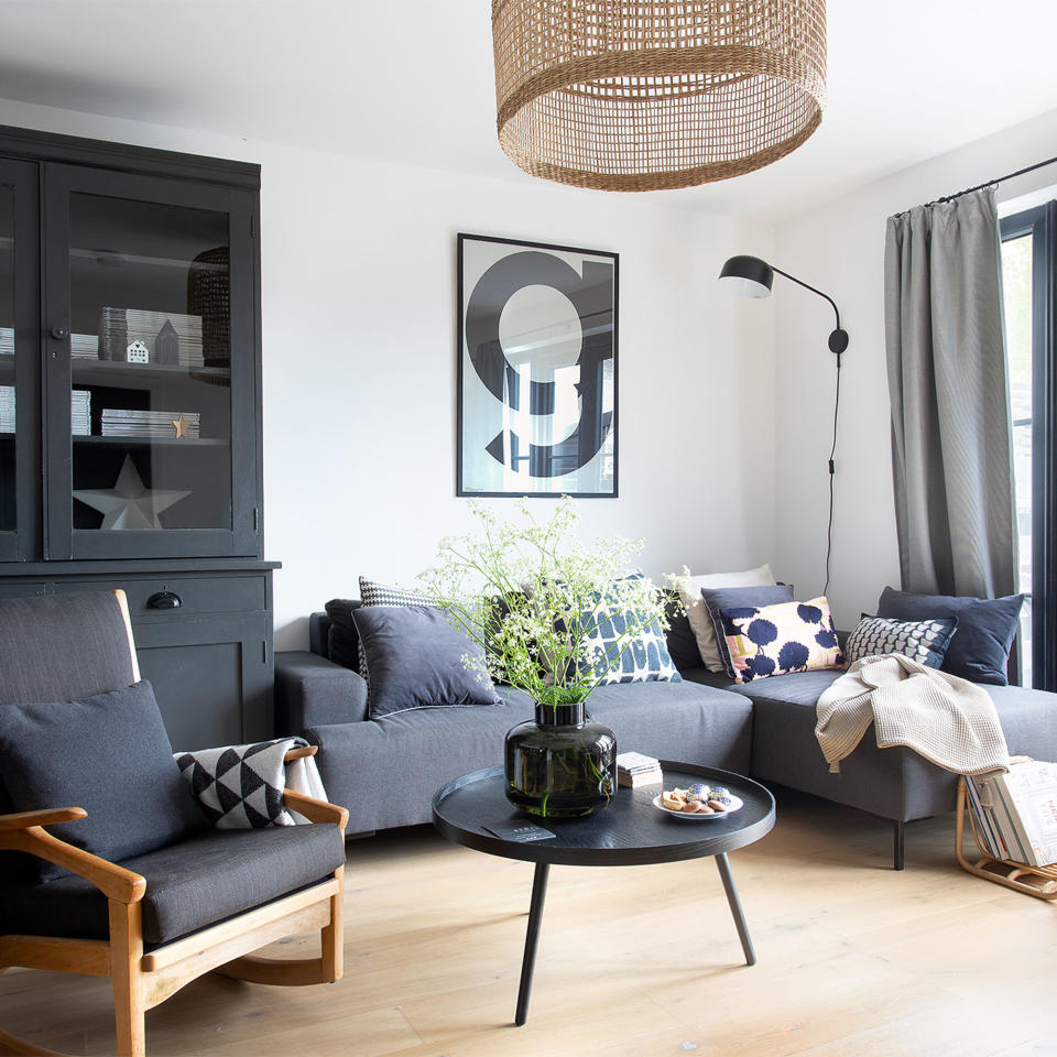  Pink chaise sofa in a beige living room with high built-in open shelves. 