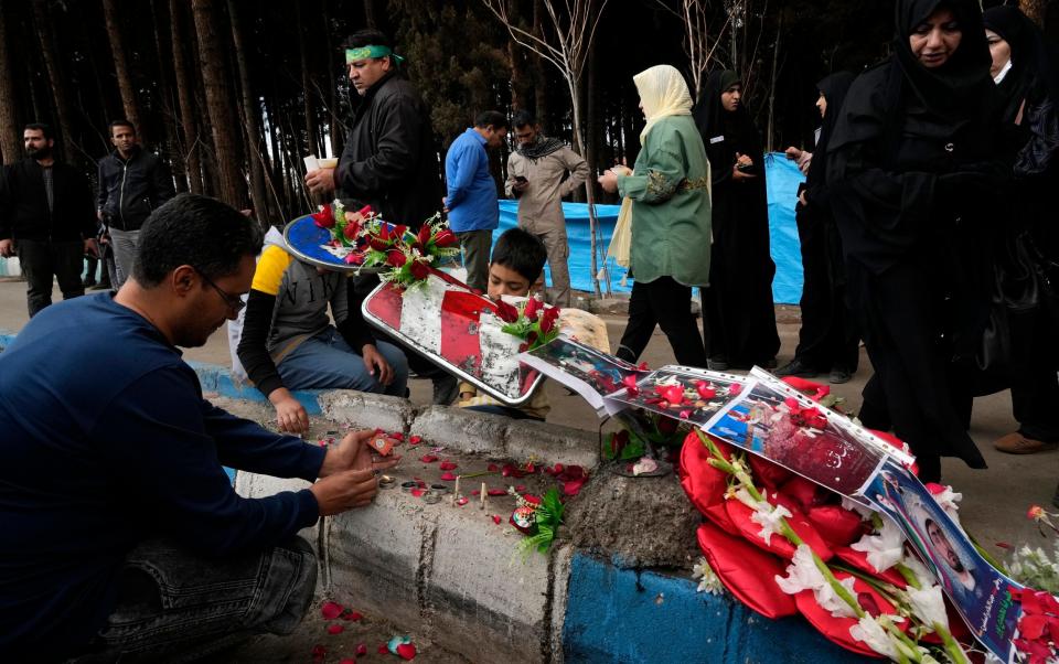 People light candles at the scene of Wednesday’s explosions