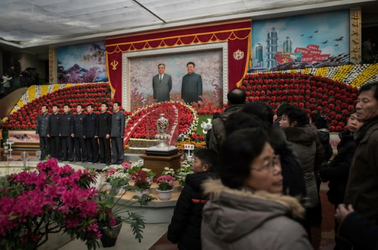 Visitors queue to have their portraits taken at the entrance to a flower show celebrating the 75th anniversary of the birth of Kim Jong-Il, in Pyongyang, on February 17, 2017