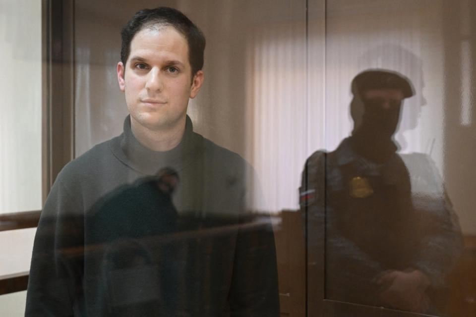 US journalist Evan Gershkovich, arrested on espionage charges, looks out from inside a defendants’ cage before a hearing to consider an appeal on his extended pre-trial detention, at the Moscow City Court in Moscow on 20 February, 2024 (AFP via Getty Images)